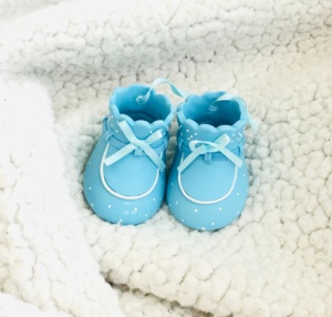 Small blue shoes on a soft blanket.