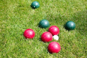 Red and green bocce balls on grass. Red and green bocce balls on grass.